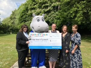 Member of staff from Southwater Event Group celebrate fundraising efforts with Hope House mascot and team.